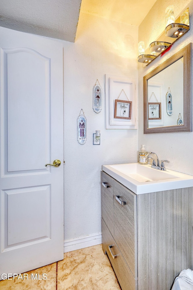 bathroom featuring baseboards and vanity