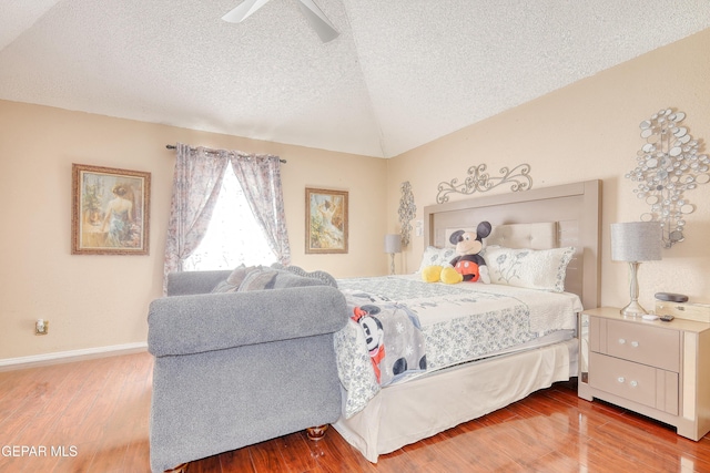 bedroom featuring vaulted ceiling, a ceiling fan, wood finished floors, and a textured ceiling