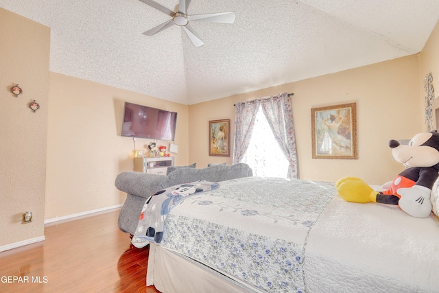 bedroom featuring a textured ceiling, vaulted ceiling, baseboards, a ceiling fan, and wood finished floors