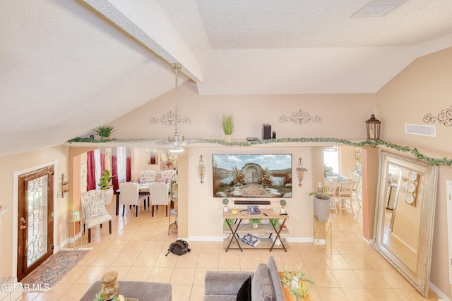 living room with vaulted ceiling, visible vents, a textured ceiling, and light tile patterned floors
