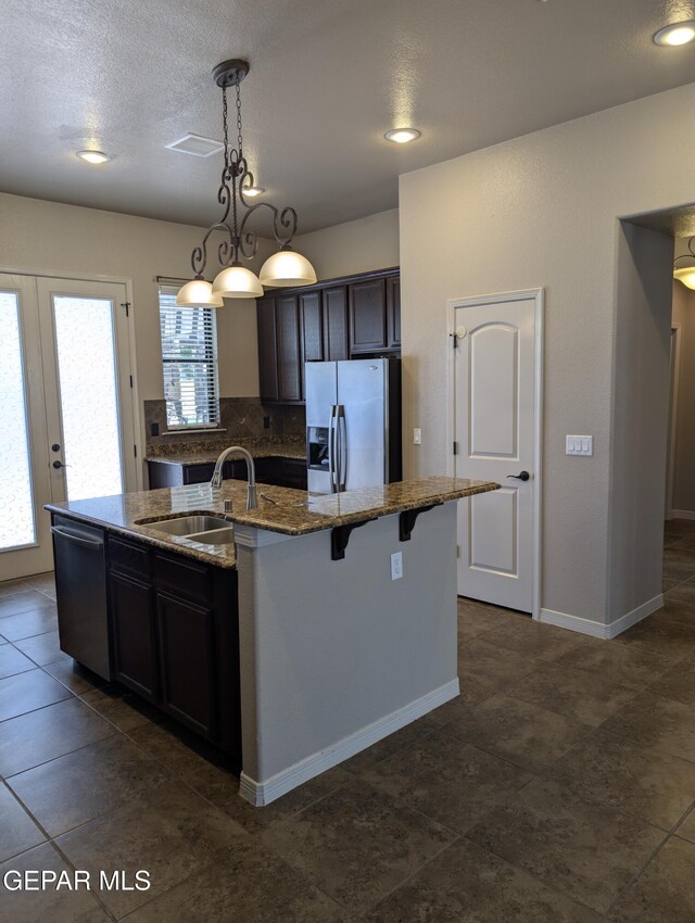 1250 Franklin Raven Place, El Paso, TX 79912 - kitchen featuring stainless steel appliances, a sink, a center island with sink, decorative backsplash, and stone countertops