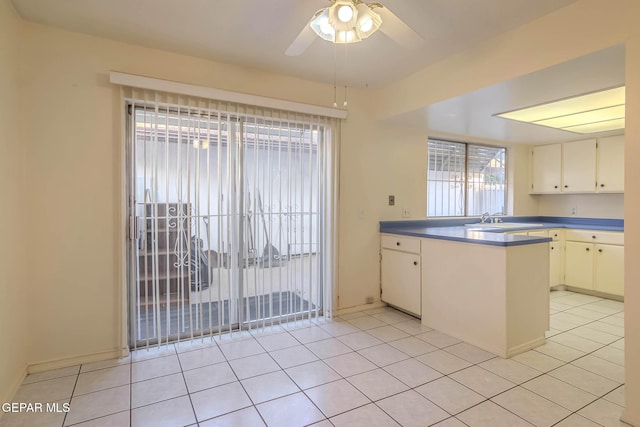 10632 Park View Cir, El Paso, TX 79935 - kitchen featuring a peninsula, ceiling fan, white cabinetry, and light tile patterned floors