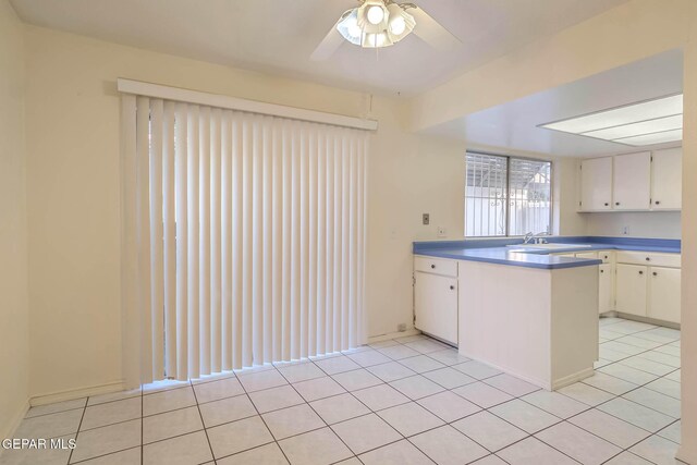 10632 Park View Cir, El Paso, TX 79935 - kitchen featuring white cabinets, a peninsula, light tile patterned floors, and ceiling fan
