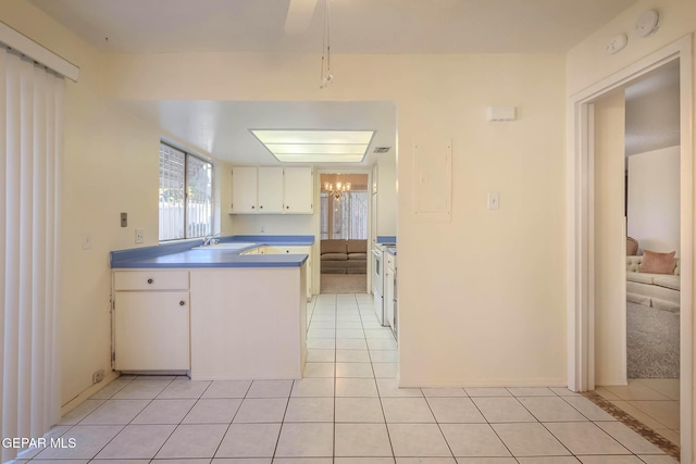 10632 Park View Cir, El Paso, TX 79935 - kitchen featuring light tile patterned floors, white cabinetry, and a sink