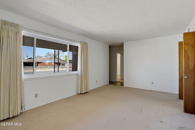 spare room featuring carpet and a textured ceiling