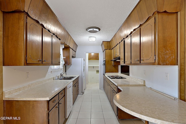 kitchen featuring a textured ceiling, dishwasher, light countertops, black stovetop, and a sink