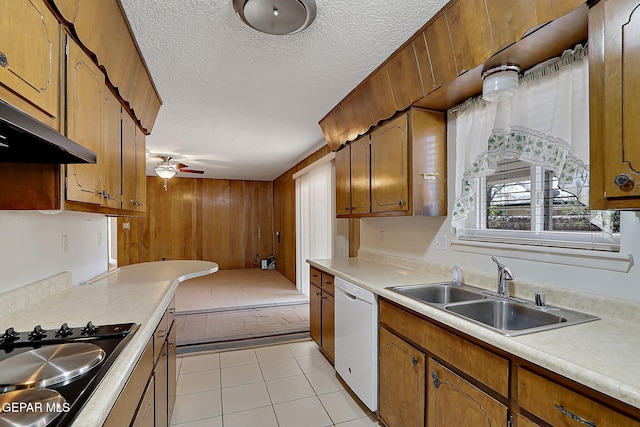 kitchen featuring light countertops, a textured ceiling, dishwasher, and a sink