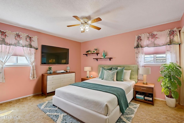 bedroom featuring baseboards, ceiling fan, carpet, and a textured ceiling