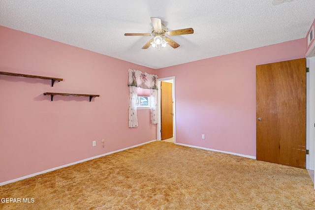carpeted empty room featuring visible vents, ceiling fan, baseboards, and a textured ceiling