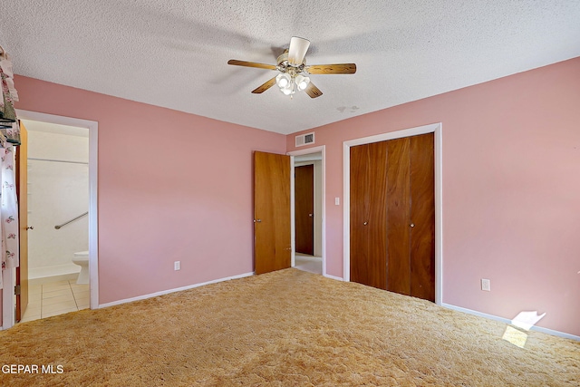 unfurnished bedroom featuring visible vents, a closet, carpet, and a textured ceiling
