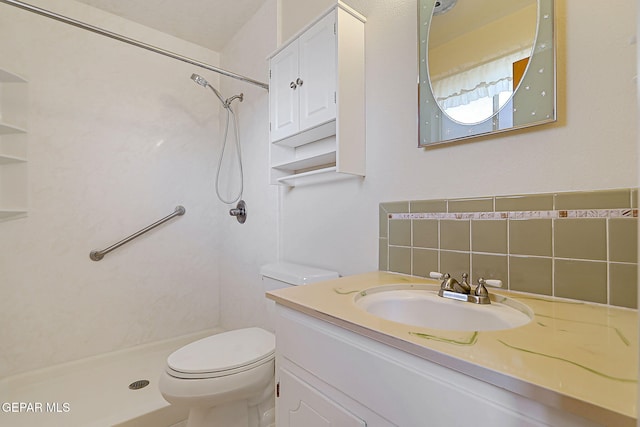 bathroom featuring a shower, tasteful backsplash, vanity, and toilet