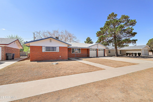ranch-style house with an attached garage, concrete driveway, and brick siding