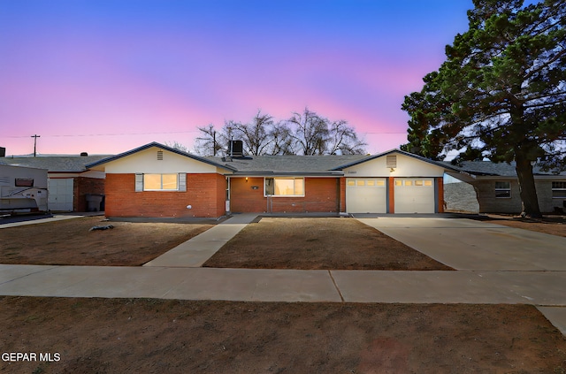 single story home with brick siding, an attached garage, a shingled roof, and concrete driveway
