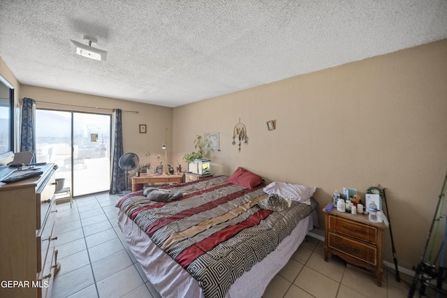 610 Gurdev Cir, Socorro, TX 79927 - bedroom with a textured ceiling, access to outside, and light tile patterned floors