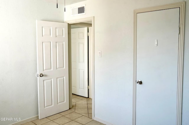 unfurnished bedroom with light tile patterned floors, baseboards, and visible vents