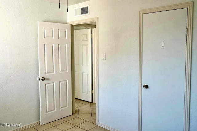 unfurnished bedroom featuring light tile patterned floors, visible vents, and baseboards