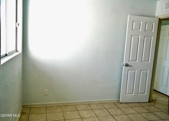 empty room with visible vents, baseboards, and light tile patterned flooring