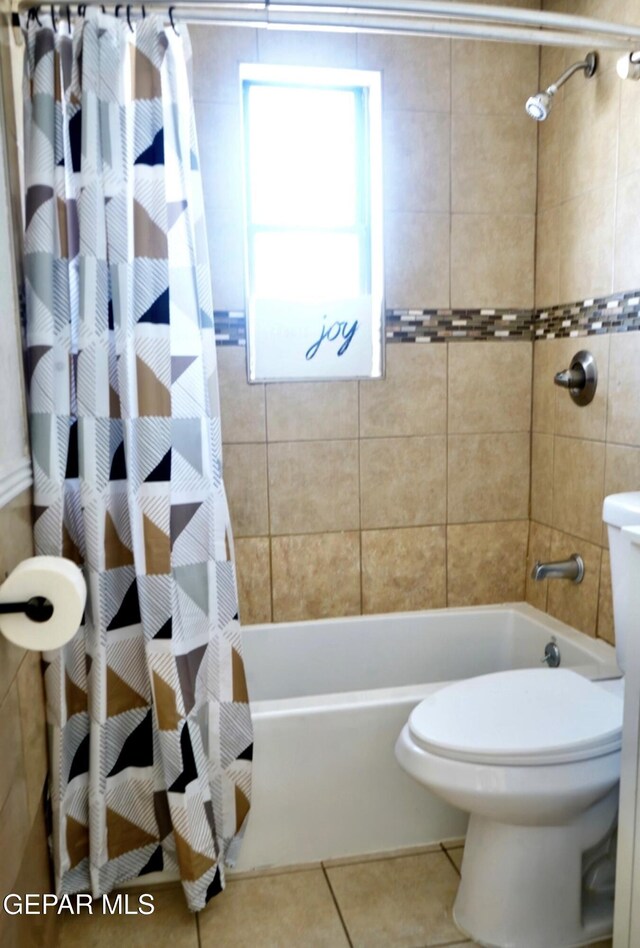 full bath featuring shower / bath combo, tile patterned flooring, and toilet