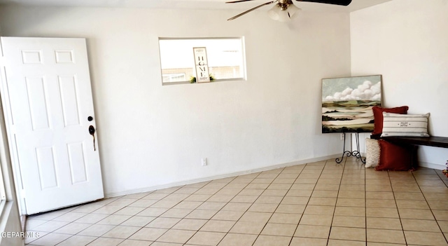 interior space featuring light tile patterned floors, baseboards, and ceiling fan