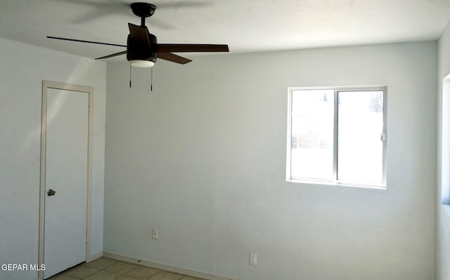 unfurnished room with light tile patterned floors, ceiling fan, and a healthy amount of sunlight