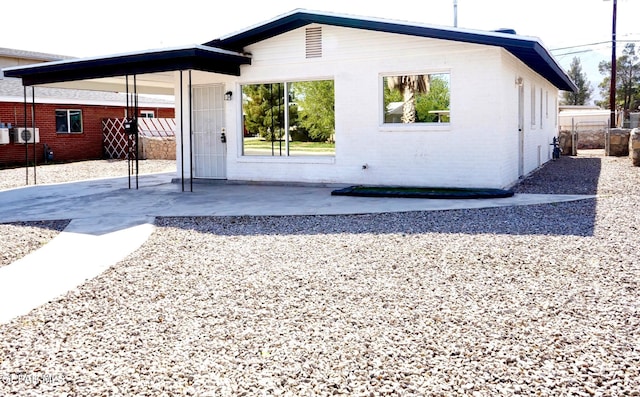 back of house with a patio area and brick siding