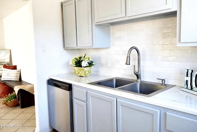 kitchen featuring light tile patterned floors, dishwasher, a sink, and decorative backsplash