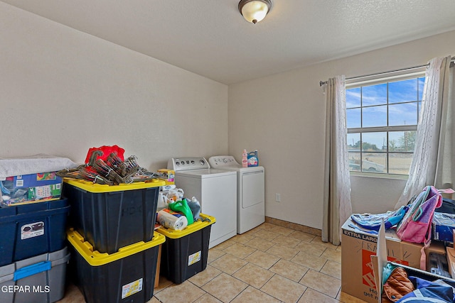 702 Thompson Rd, San Elizario, TX 79849 - clothes washing area with light tile patterned floors, washer and clothes dryer, laundry area, and a textured ceiling