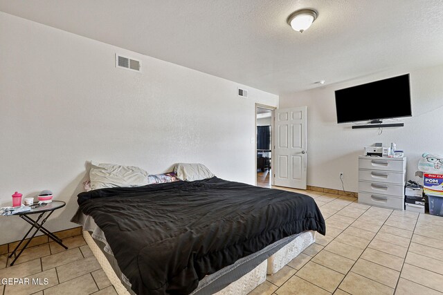 702 Thompson Rd, San Elizario, TX 79849 - bedroom featuring visible vents, a textured ceiling, and light tile patterned flooring