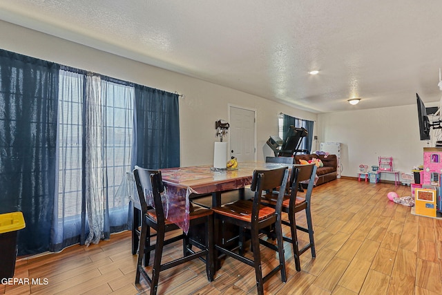 702 Thompson Rd, San Elizario, TX 79849 - dining space with a healthy amount of sunlight, light wood-type flooring, and a textured ceiling
