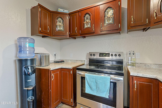 702 Thompson Rd, San Elizario, TX 79849 - kitchen featuring stainless steel range with electric stovetop and brown cabinetry