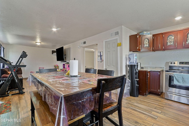 702 Thompson Rd, San Elizario, TX 79849 - dining room featuring light wood finished floors, visible vents, and a textured ceiling
