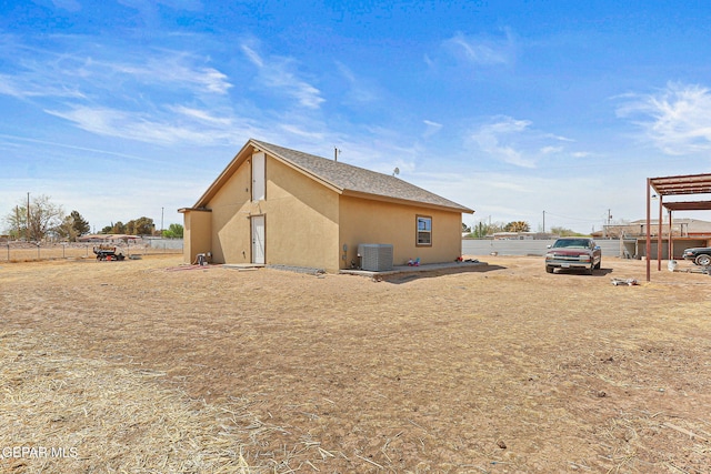 702 Thompson Rd, San Elizario, TX 79849 - rear view of house featuring stucco siding, central AC, and fence