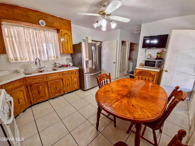 7726 Monterrey Dr, El Paso, TX 79915 - kitchen with light tile patterned floors, a sink, light countertops, appliances with stainless steel finishes, and brown cabinets
