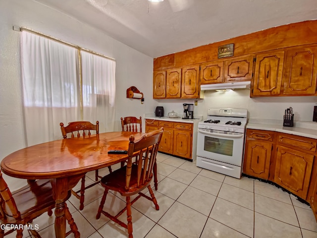 7726 Monterrey Dr, El Paso, TX 79915 - kitchen featuring light countertops, brown cabinets, under cabinet range hood, and white range with gas cooktop
