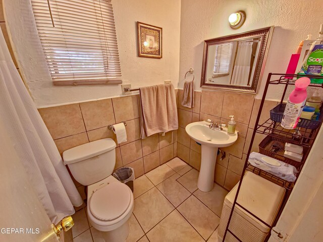 7726 Monterrey Dr, El Paso, TX 79915 - bathroom with toilet, tile walls, tile patterned flooring, and wainscoting