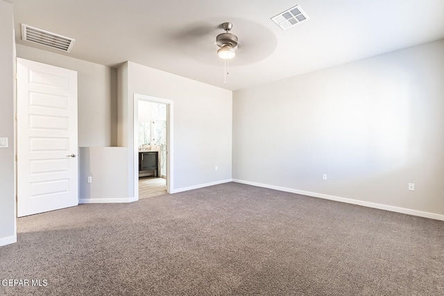 carpeted spare room featuring baseboards, a ceiling fan, and visible vents
