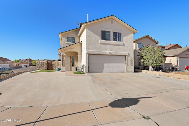 traditional-style home featuring stucco siding, a garage, concrete driveway, and fence