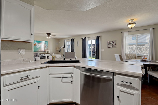 kitchen with dishwasher, a sink, ceiling fan, white cabinets, and a textured ceiling