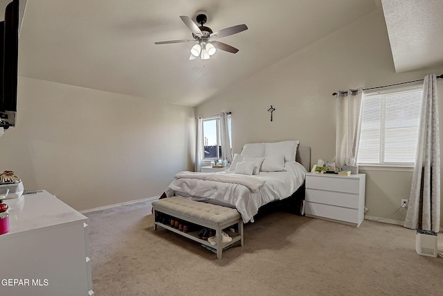 bedroom featuring light colored carpet, lofted ceiling, baseboards, and ceiling fan