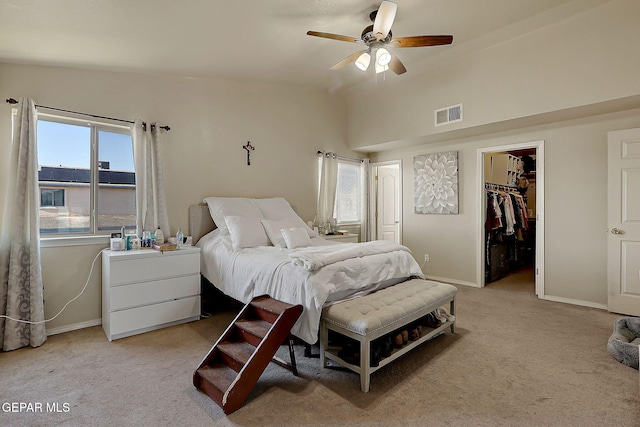 bedroom with carpet, a walk in closet, baseboards, lofted ceiling, and a closet