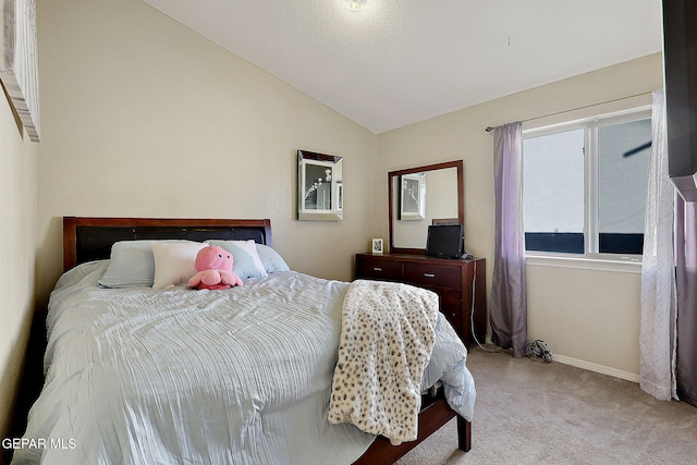 bedroom with lofted ceiling, carpet flooring, and baseboards