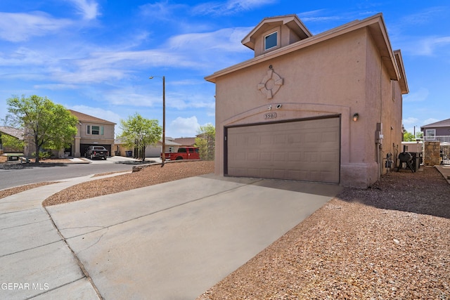 3501 Al Roberts Dr, El Paso, TX 79936 - view of property exterior featuring a garage, driveway, and stucco siding