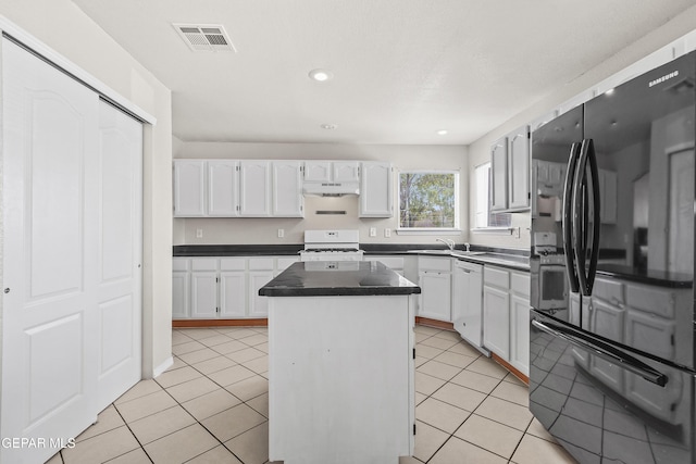 3501 Al Roberts Dr, El Paso, TX 79936 - kitchen featuring white appliances, white cabinets, visible vents, a kitchen island, and dark countertops