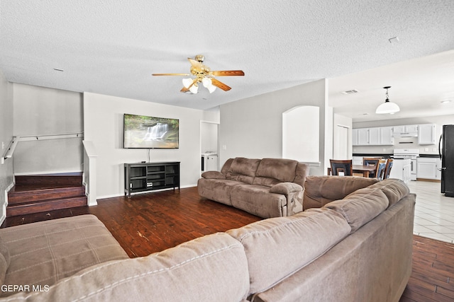 3501 Al Roberts Dr, El Paso, TX 79936 - living room featuring visible vents, baseboards, a ceiling fan, a textured ceiling, and wood finished floors