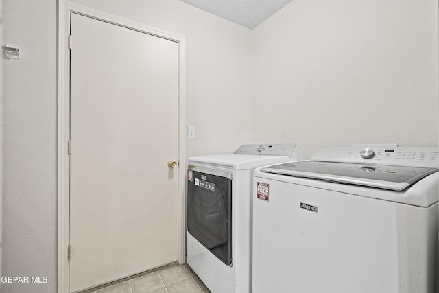 3501 Al Roberts Dr, El Paso, TX 79936 - washroom with laundry area, light tile patterned flooring, a textured ceiling, and washer and clothes dryer