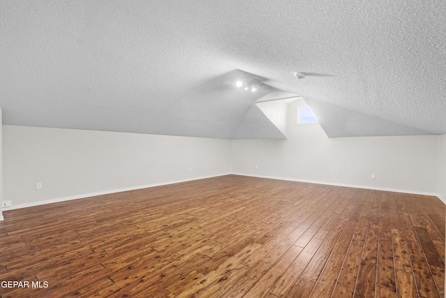 3501 Al Roberts Dr, El Paso, TX 79936 - additional living space featuring wood-type flooring, baseboards, vaulted ceiling, and a textured ceiling