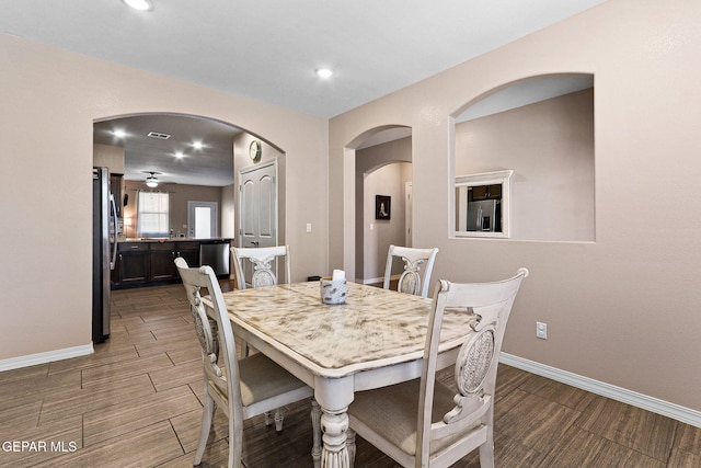 14439 Eastbrook Dr, El Paso, TX 79938 - dining room featuring arched walkways, baseboards, and wood finished floors