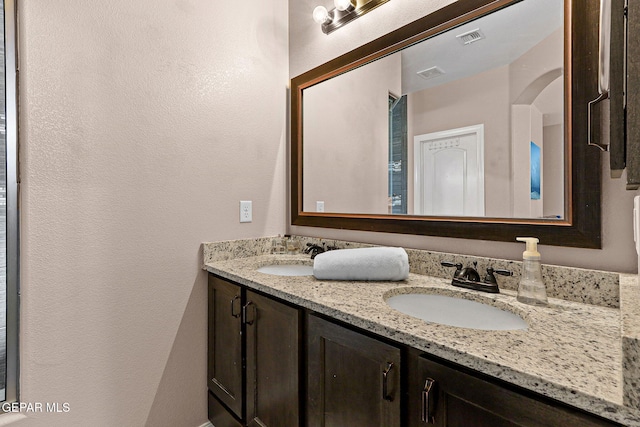 14439 Eastbrook Dr, El Paso, TX 79938 - bathroom featuring a textured wall, double vanity, visible vents, and a sink