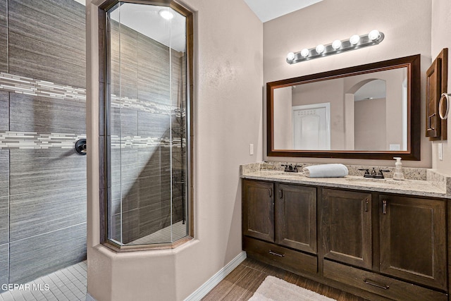 14439 Eastbrook Dr, El Paso, TX 79938 - bathroom featuring tiled shower, tile patterned flooring, a sink, double vanity, and baseboards