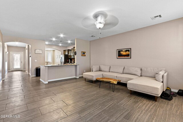 14439 Eastbrook Dr, El Paso, TX 79938 - living room with visible vents, baseboards, a ceiling fan, and arched walkways